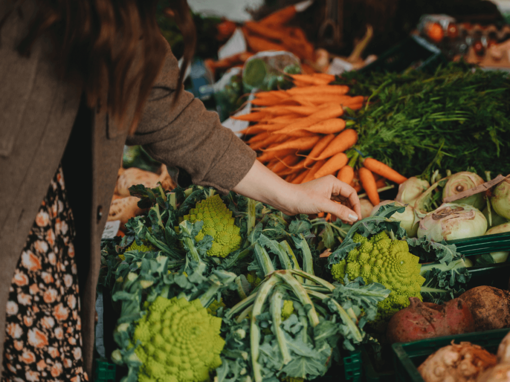 femme achète des légumes au marché pour cuisiner